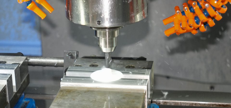 End mill cutting a machined part held in a vise inside a CNC machining center